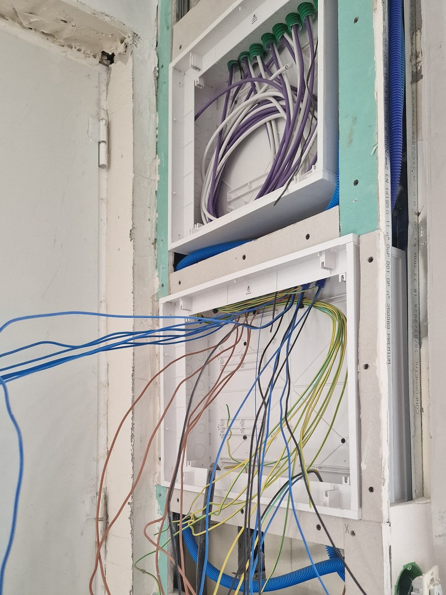 Caixas do ATI e do quadro elétrico embutidas na parede, com cablagem por ligar — Jasmim Faria